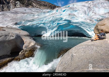 Backpacker admire Nigardsbreen Nigar Glacier bras de Jostedalsbreen situé dans la vallée de Gaupne Jostedalen en Norvège Banque D'Images