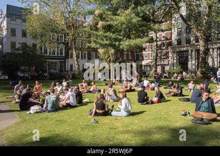 Les jeunes bronzer et se détendre dans Soho Square Gardens, Soho Square, Soho, Londres, W1, Angleterre, Royaume-Uni Banque D'Images