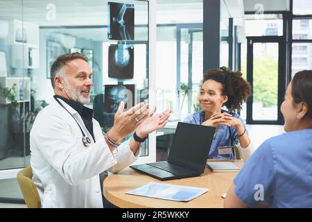 Nous ne pouvons le faire qu'en équipe. une équipe de médecins ayant une réunion dans un hôpital. Banque D'Images