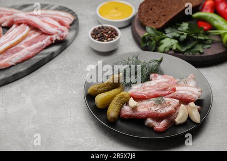 Savoureux fatback de porc, concombres marinés et ingrédients sur table grise Banque D'Images