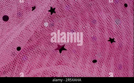 Tissu net avec embellissement d'étoile et de cercle. Tissu de filet coloré rose. Image maillée abstraite pour arrière-plan ou arrière-plan. Banque D'Images