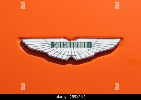 Écusson Aston Martin emblématique sur le capot d'une voiture de sport DB9 peinte dans la décoration classique de course bleu et orange Gulf Oils, mai 2023. Banque D'Images