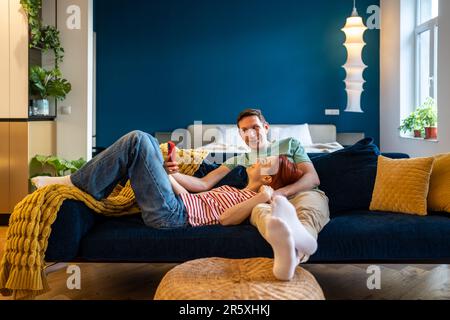Joyeux couple de famille homme femme faisant le selfie sur smartphone regardant l'écran à la maison. Banque D'Images