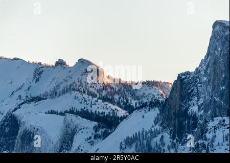 Tôt le soleil attrapant les sommets enneigés de la Sierra Nevadas dans le parc national de Yosemite. Banque D'Images