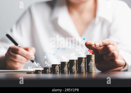 Femme d'affaires main et pile pièces argent avec la flèche vers le haut et le symbole de pourcentage des taux d'intérêt financier et hypothécaire taux. Icône symbole de pourcentage an Banque D'Images