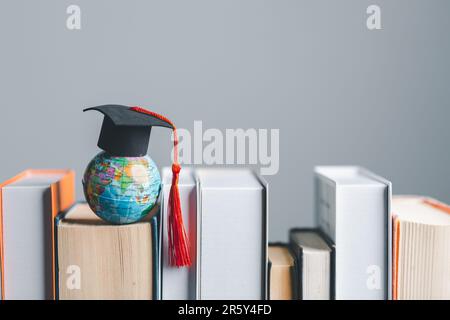 Capuchon de graduation avec globe terrestre. Concept d'étude mondiale des affaires, enseignement à l'étranger, rentrée scolaire. L'éducation dans le monde mondial, étudier à l'étranger Banque D'Images