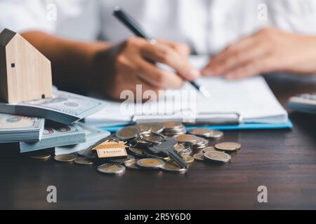 Audit et concept fiscal de l'énergie de l'immobilier. Vérification de la position d'origine. Modèle de maison avec agent immobilier professionnel avec le client pour la signature de bail de location contra Banque D'Images