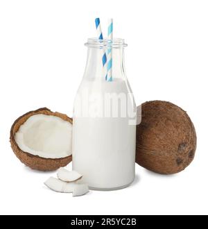 Bouteille en verre de délicieux lait végétalien et noix de coco sur fond blanc Banque D'Images