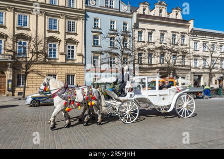 Cracovie, Pologne - 11 mars 2022 : une calèche équestre sur la place principale de Cracovie, dans la province de Malopolskie, en Pologne. Attraction touristique populaire, cheval Banque D'Images