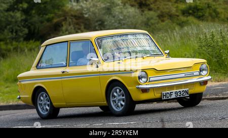 Stony Stratford, Royaume-Uni - 4 juin 2023: 1975 jaune HILLMAN IMP voiture classique voyageant sur une route de campagne anglaise. Banque D'Images