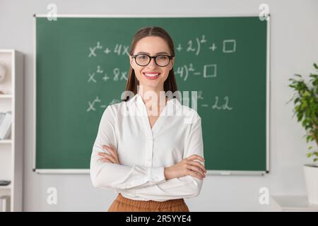 Portrait du jeune professeur de mathématiques près du tableau noir en classe Banque D'Images