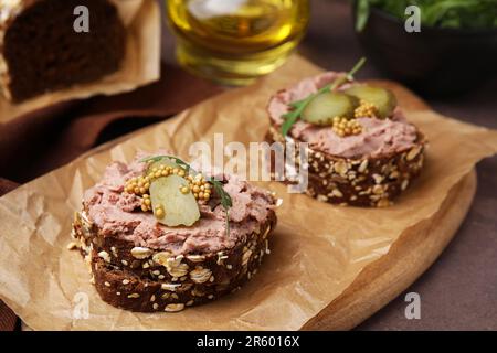 Délicieux sandwichs de livrewurst avec concombre mariné et moutarde sur table grise, en gros plan Banque D'Images