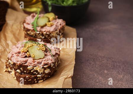 Délicieux sandwichs de livrewurst avec concombre mariné et moutarde sur table grise, en gros plan. Espace pour le texte Banque D'Images