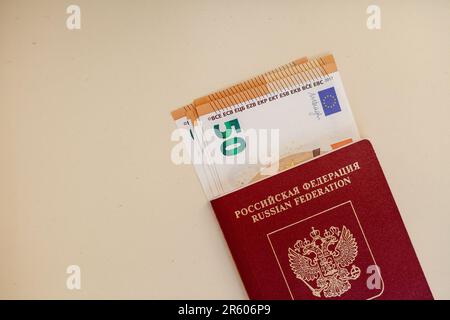 Passeport russe étranger dans lequel il y a des dollars ou des euros pour voyager à la frontière. Concept de vacances, de migration ou de voyage. Banque D'Images