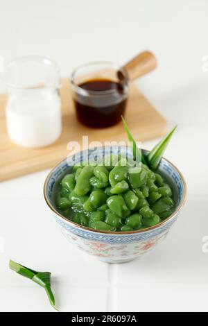 LOD Chong ou Cendol est un dessert sucré glacé, servi avec du sirop de sucre de palme et du lait de noix de coco, sur table blanche. Banque D'Images