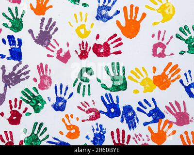 Empreintes de main colorées pour enfants sur fond blanc avec des empreintes de main rouges, orange, bleues, vertes et jaunes. Banque D'Images