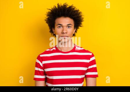 Photo portrait de drôle de la diversité Guy regarder sérieusement sur l'appareil photo photographier porter chemise rayée isolé couleur jaune arrière-plan Banque D'Images