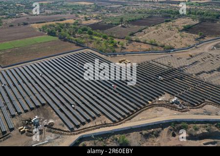 Une vue aérienne d'une grande ferme solaire avec un ensemble de panneaux solaires noirs disposés en rangées nettes Banque D'Images