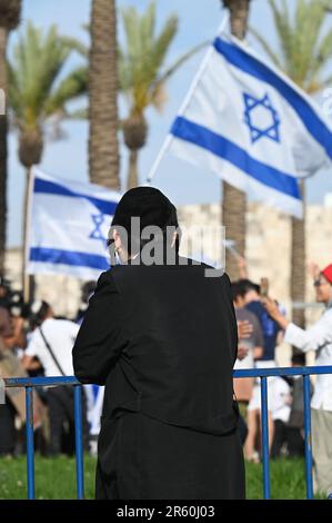 Un adolescent de Haredi regardant les drapeaux israéliens Banque D'Images