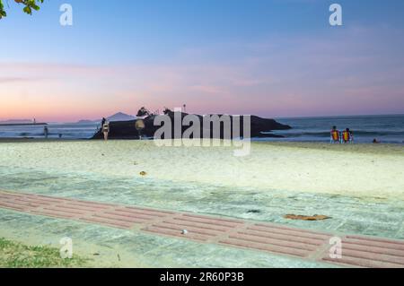 Plage de Cabeçudas dans itajai-sc brésil, en fin d'après-midi et les gens sur leur dos appréciant la plage, cargo arrivant dans la ville en arrière-plan, s Banque D'Images
