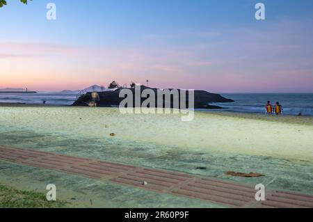 Plage de Cabeçudas dans itajai-sc brésil, en fin d'après-midi et les gens sur leur dos appréciant la plage, cargo arrivant dans la ville en arrière-plan, s Banque D'Images