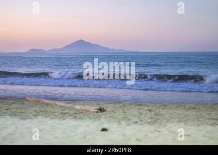 Plage de Cabeçudas dans itajai-sc brésil, en fin d'après-midi et les gens sur leur dos appréciant la plage, cargo arrivant dans la ville en arrière-plan, s Banque D'Images