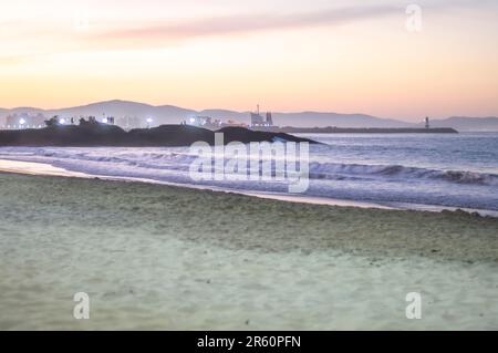 Plage de Cabeçudas dans itajai-sc brésil, en fin d'après-midi et les gens sur leur dos appréciant la plage, cargo arrivant dans la ville en arrière-plan, s Banque D'Images