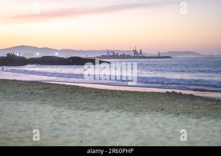 Plage de Cabeçudas dans itajai-sc brésil, en fin d'après-midi et les gens sur leur dos appréciant la plage, cargo arrivant dans la ville en arrière-plan, s Banque D'Images