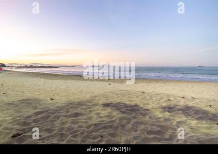 Plage de Cabeçudas dans itajai-sc brésil, en fin d'après-midi et les gens sur leur dos appréciant la plage, cargo arrivant dans la ville en arrière-plan, s Banque D'Images