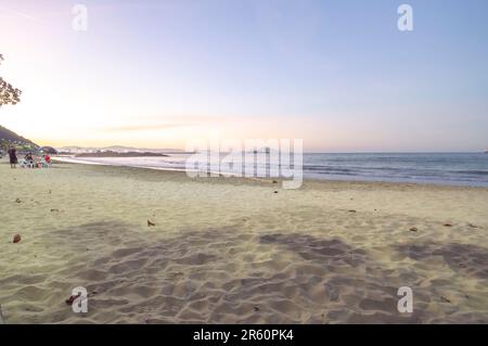 Plage de Cabeçudas dans itajai-sc brésil, en fin d'après-midi et les gens sur leur dos appréciant la plage, cargo arrivant dans la ville en arrière-plan, s Banque D'Images