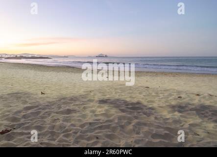 Plage de Cabeçudas dans itajai-sc brésil, en fin d'après-midi et les gens sur leur dos appréciant la plage, cargo arrivant dans la ville en arrière-plan, s Banque D'Images