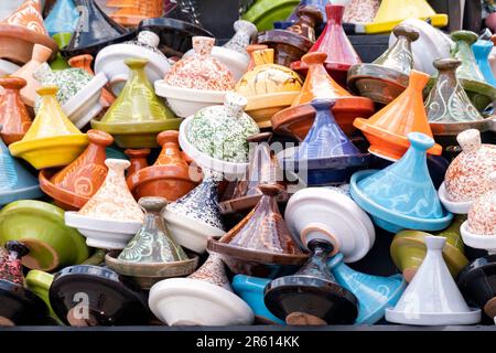 Tajines ou tajines marocaines assorties peintes et glacées à vendre dans un souk ou un marché au Maroc. les tagines sont empilées haut sur la stalle Banque D'Images