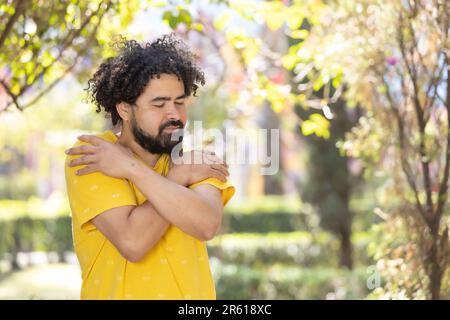 Un homme debout dans une posture étreinte à l'extérieur du parc Banque D'Images