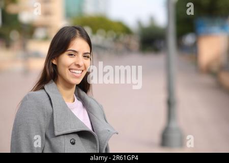 En hiver, une femme heureuse qui rit debout dans la rue vous regarde Banque D'Images