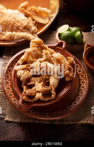 Chicharron. La croûte de porc frite et croustillante est composée de morceaux de peau de porc frite et aérée, d'ingrédients mexicains traditionnels ou d'en-cas servis avec du jus de lime et du ho rouge Banque D'Images