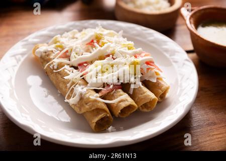 Tacos Dorados. Le plat mexicain également connu sous le nom de Flatas, se compose d'une tortilla de maïs roulé avec un peu de garniture, communément poulet ou boeuf ou option végétarienne Banque D'Images