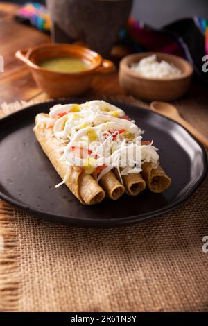 Tacos Dorados. Le plat mexicain également connu sous le nom de Flatas, se compose d'une tortilla de maïs roulé avec un peu de garniture, communément poulet ou boeuf ou option végétarienne Banque D'Images