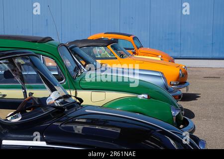 Les véhicules Volkswagen de couleurs variées garés devant un mur de briques Banque D'Images