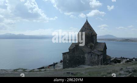 Complexe du monastère de Sevanananananank en Arménie. Le bâtiment du monastère avec la croix est vu de l'arrière-plan, sur le fond du lac Sevan, la haute neige Banque D'Images