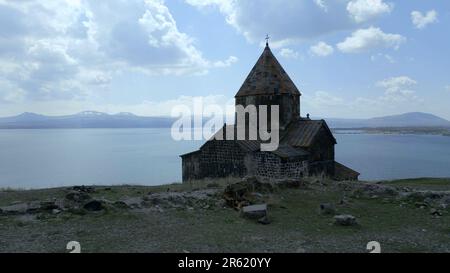 Complexe du monastère de Sevanananananank en Arménie. Le bâtiment du monastère avec la croix est vu de l'arrière-plan, sur le fond du lac Sevan, la haute neige Banque D'Images