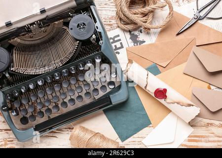 Composition avec machine à écrire vintage, rouleau et enveloppes sur table en bois blanc Banque D'Images