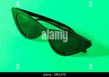 Lunettes de soleil noires élégantes sur fond turquoise Banque D'Images