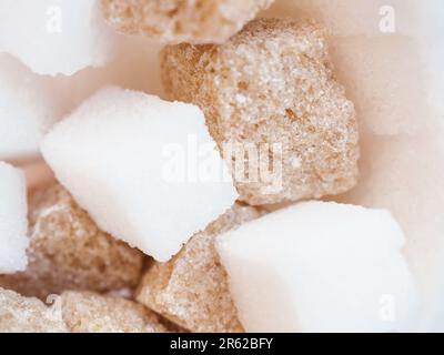 Vue macro du mélange de sucre brut. Cubes de sucre brun et blanc. Mise au point sélective. Banque D'Images