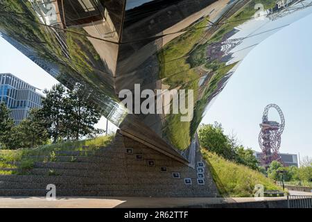 Sous un pont réfléchissant sur la rivière Lea, dans le parc olympique de Stratford, en regardant vers la tour Orbit par temps ensoleillé. Londres Banque D'Images