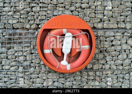 Bouée de sauvetage sur le mur de briques d'un canal Banque D'Images