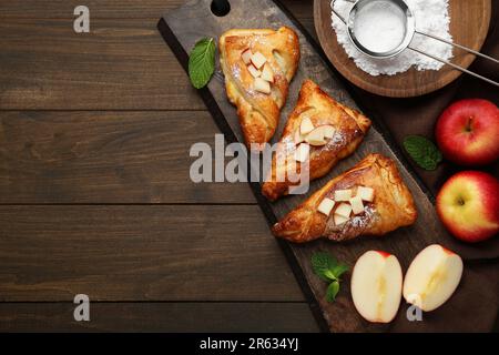 Pâte fraîche et savoureuse avec sucre en poudre, menthe et pommes servies sur une table en bois, à plat. Espace pour le texte Banque D'Images