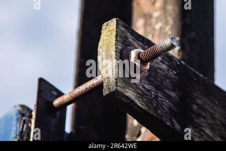 Rouille sur l'écrou, la vis et la rondelle pour une fixation longue sur l'ancienne plaque de bois. Banque D'Images