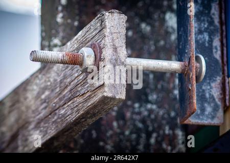 Rouille sur l'écrou, la vis et la rondelle pour une fixation longue sur l'ancienne plaque de bois. Banque D'Images