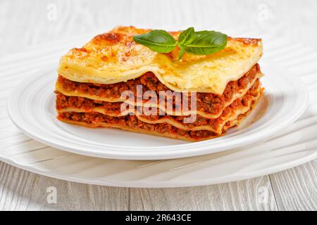 portion de lasagnes al forno, lasagnes de bœuf italien avec du bœuf haché, sauce marinara, nouilles de pâtes et fromage ricotta sur une assiette blanche sur le blanc w. Banque D'Images