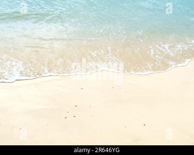 Gros plan, vagues touchant la plage de sable. Mer tropicale, plage vide. Banque D'Images